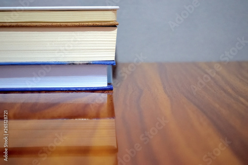group of books on a wooden table with grey background  