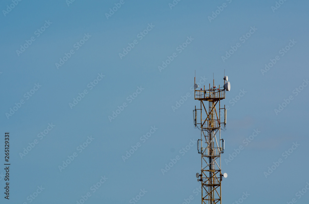 Telecommunication 5G tower on blue sky blank background. Used to transmit television and telephony signal Telecommunication 5G tower on blue sky blank background. Used to transmit television and telephony signal