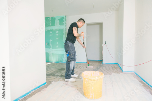 Haus im Bau.  Fussboden oberfläche grundieren und nivellieren.