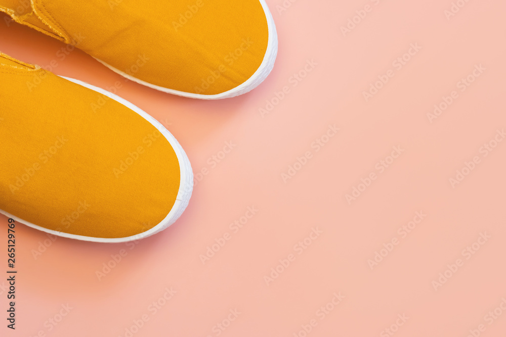 Orange slip-on shoes on pink trendy background. Copy space for text. Unisex shoes for every day. Orange slip-on shoes on pink trendy background. Copy space for text. Unisex shoes for every day.