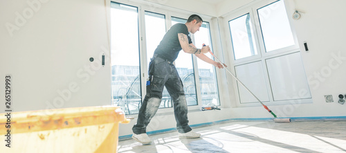 Haus im Bau. Fussboden oberfläche grundieren und nivellieren.