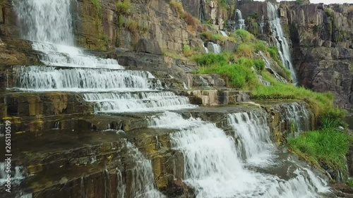 Aerial close details Pongour falls largest full-flowing multi-tiered waterfall rock cascades tropical natural wild landscape. Exotic stones covered moss. Dalat Vietnam landmark nobody. Sunny. Travel photo