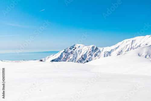 The japan alps  or the snow mountains wall  of Tateyama Kurobe alpine  in sunshine day with  blue sky background is one of the most important and popular natural place in Toyama Prefecture, Japan. © Umarin