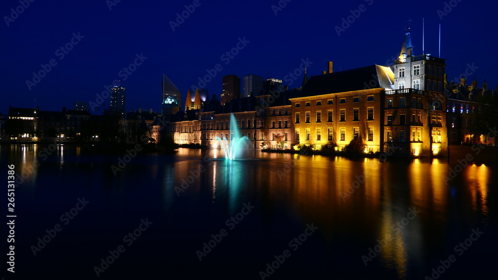Beautiful view by night to the House of parliament within the historical Binnenhof with the modern city of the Hague in the background, Netherlands