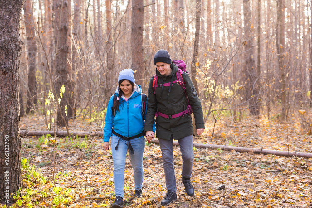 adventure, travel, tourism, hike and people concept - smiling couple walking with backpacks over autumn natural background adventure, travel, tourism, hike and people concept - smiling couple walking with backpacks over autumn natural background