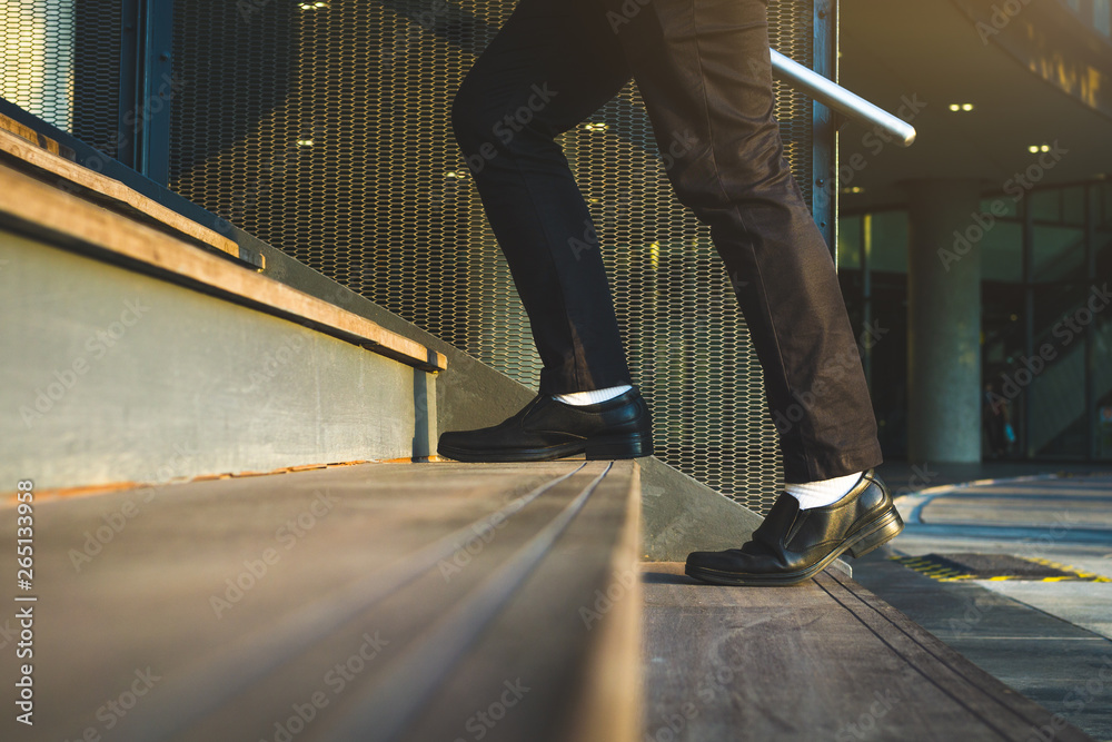 Fototapeta premium Businessman legs walking up the stairs