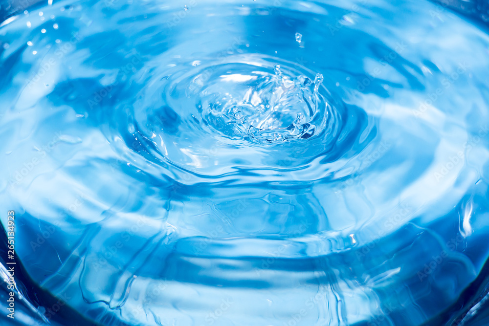 Splashes from a drop of water. Rain drops on a blue background. The texture of the water. Aqua, ripple, turquoise, macro Splashes from a drop of water. Rain drops on a blue background. The texture of the water. Aqua, ripple, turquoise, macro