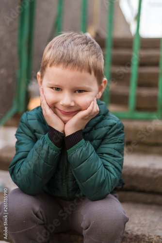 Portrait of a little boy in a jacket on the street.