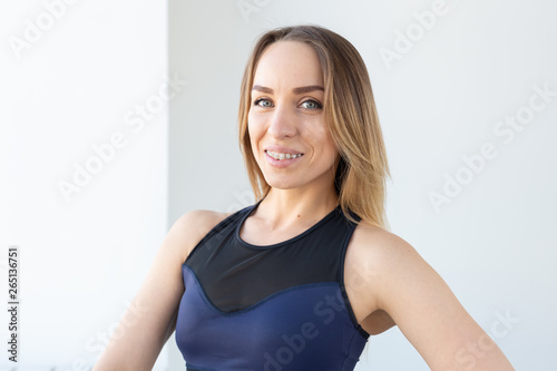 people, sport and fitness concept - portrait of young brunette fitness woman on white background