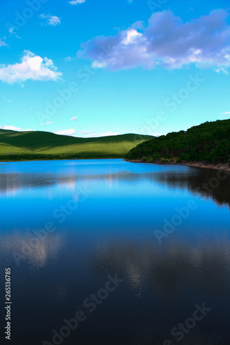 Beautiful lake with specular shine in soft mountains 