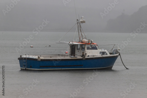 Small fishing boat anchored offshore 