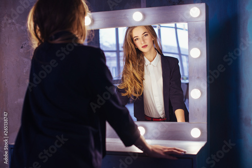 happy woman watching on herself in a big mirror photo