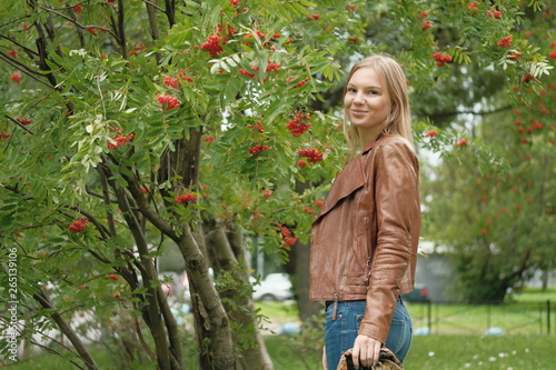 Beautiful blond girl posing for photo in park with wildberry