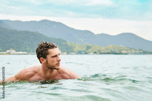 Young dude swimming in sea, looking away © sanneberg