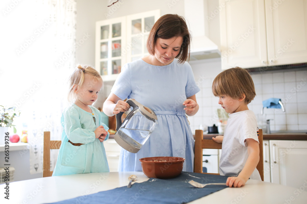 Caucasian brother and sister help mom to cook Caucasian brother and sister help mom to cook