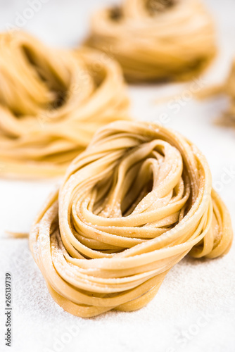 Italian spaghetti raw pasta on white marble table