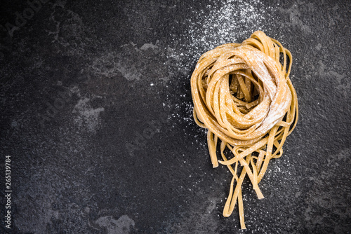 Raw uncooked pasta on dark slate, copyspace