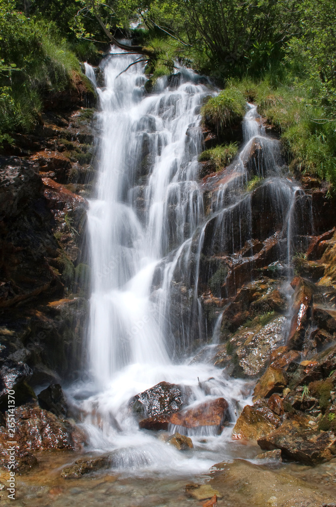 La bella cascatella con le candide acque, nel torrente di montagna