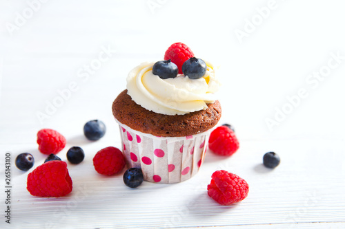 Homemade cupcakes with berries on a wooden background