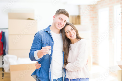 Beautiful young couple hugging in love and showing keys of new house, smiling happy moving to a new apartment © Krakenimages.com