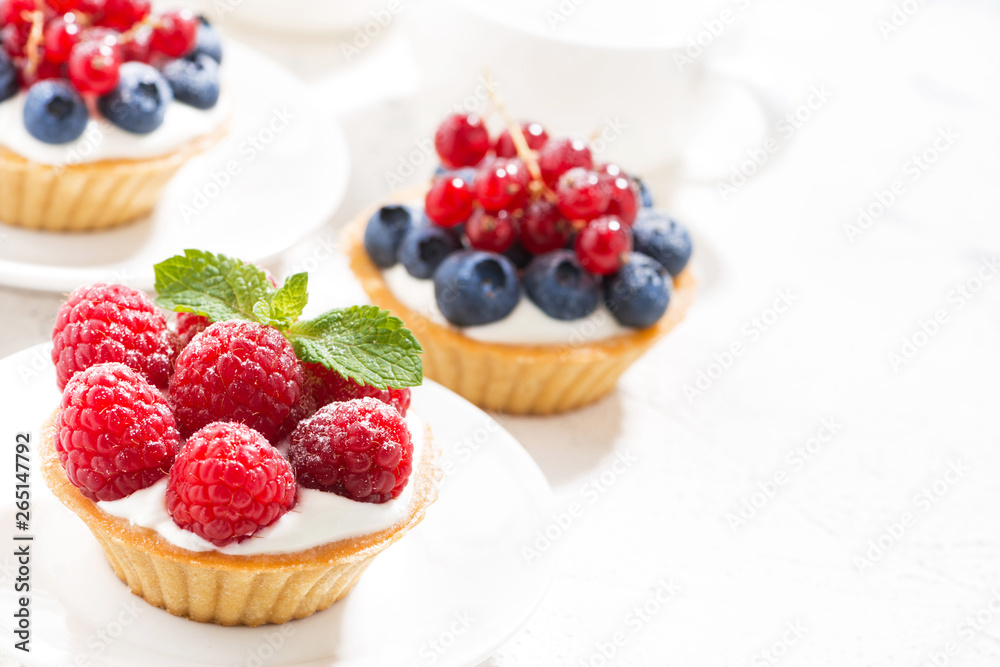 mini tarts with cream and berries on white background mini tarts with cream and berries on white background