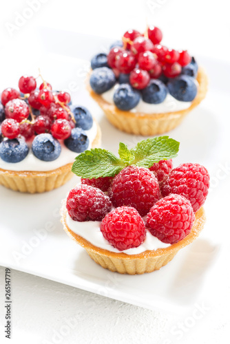 mini cakes with cream and berries, top view vertical