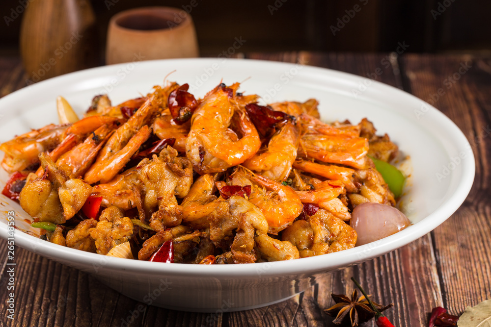 Fried spicy bullfrog and chicken with chilli in a white ceramic dish