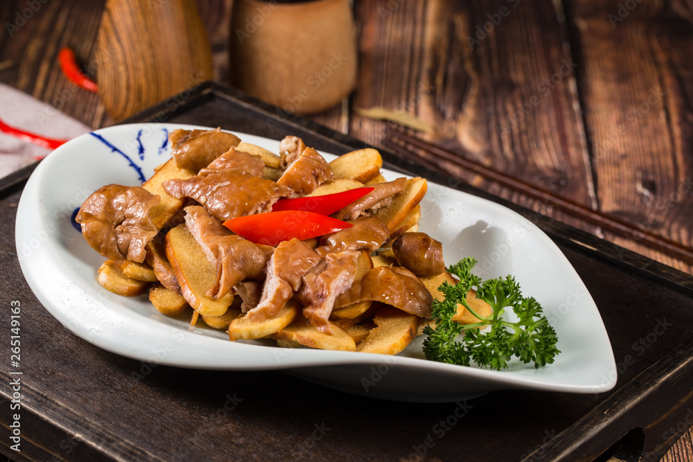Braise pig's large intestines in soy sauce in a white ceramic dish Braise pig's large intestines in soy sauce in a white ceramic dish