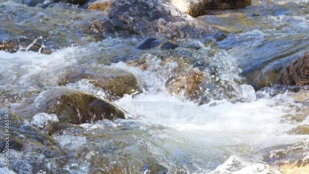 Slow motion of beautiful mountain river cascading over river stones Slow motion of beautiful mountain river cascading over river stones