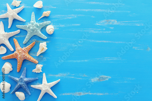 vacation and summer concept with starfish and seashells over blue wooden background. Top view flat lay