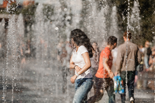 Fototapeta Naklejka Na Ścianę i Meble -  Young people bathing in a city fountain