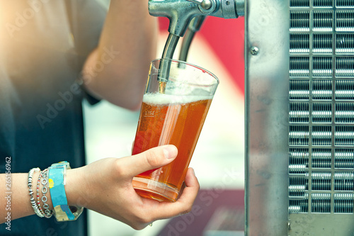 Girl's hand while tapping beer in a platyrus mug at a folk festival