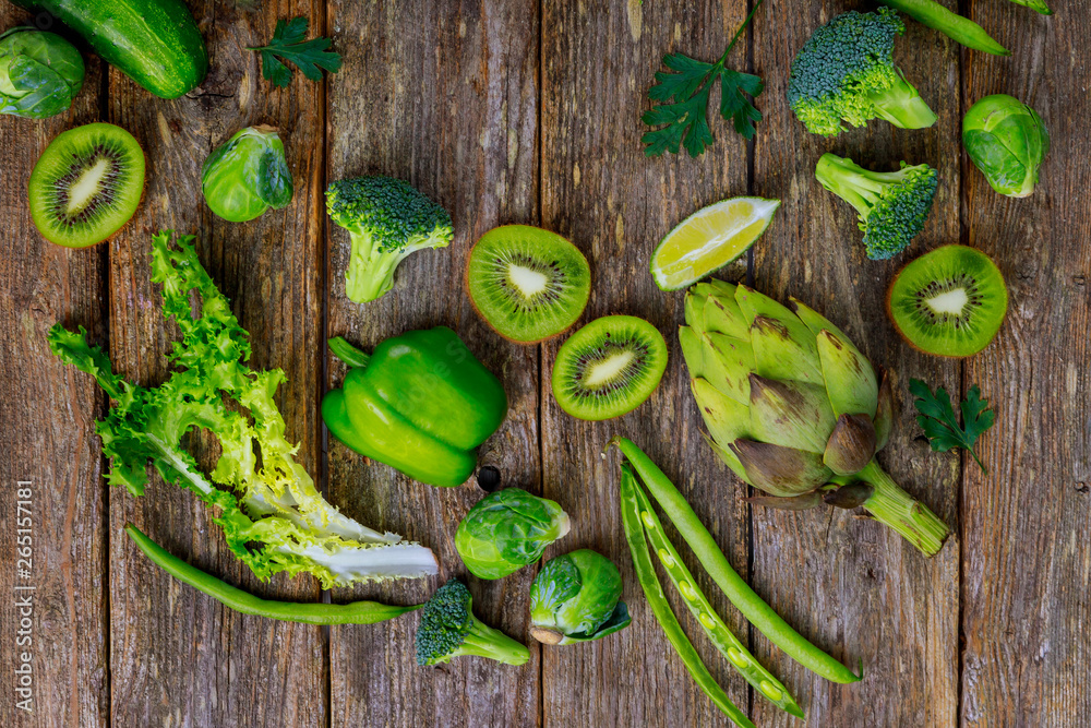 Fresh green vegetables on a wood background.