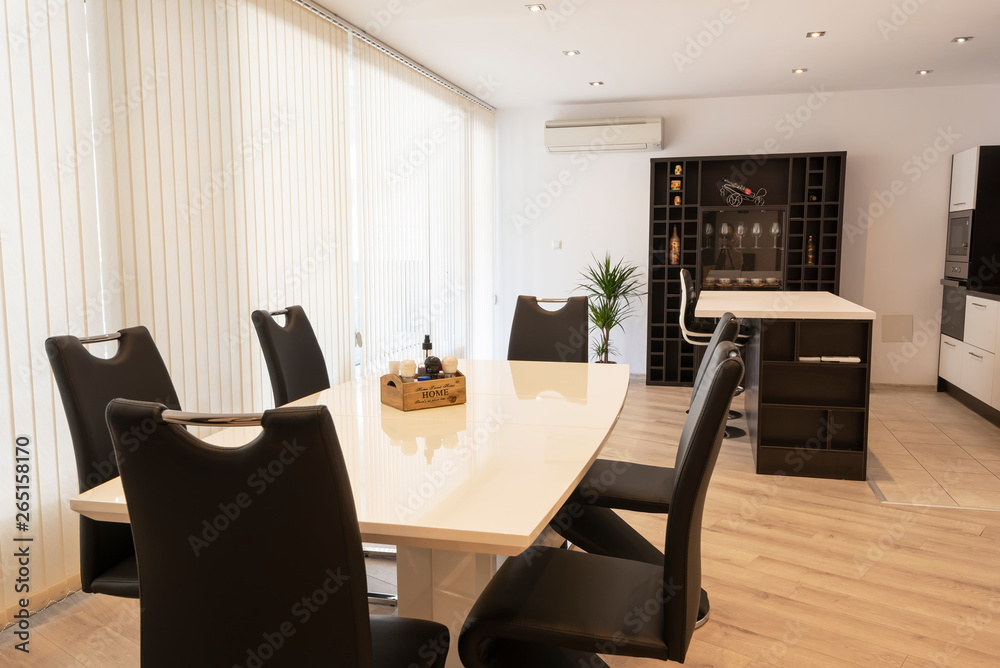 Interior of kitchen and dining room, white kitchen cabinetry and steel appliances. Interior photography. Open space living room with kitchen Interior of kitchen and dining room, white kitchen cabinetry and steel appliances. Interior photography. Open space living room with kitchen