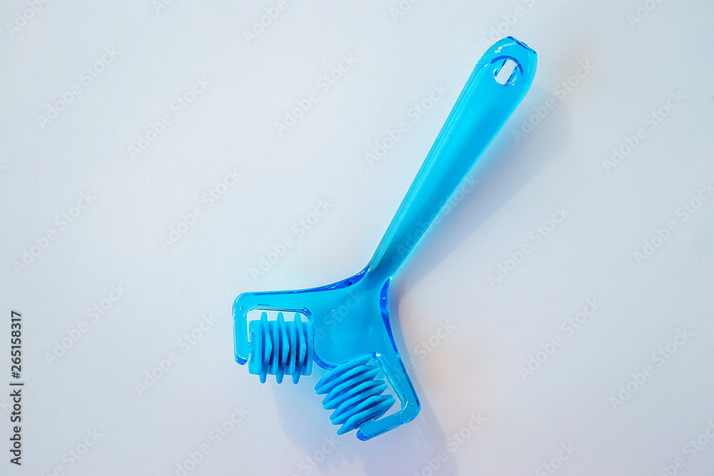 Plastic blue facial massager on a white background. Plastic blue facial massager on a white background.