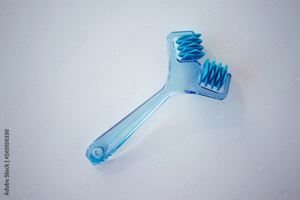 Plastic blue facial massager on a white background.
