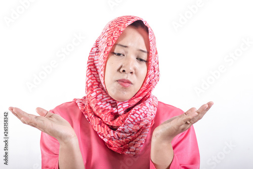 Asian muslim business women wearing hijab with shrug shoulder up gesture, showing i don't know or rejection