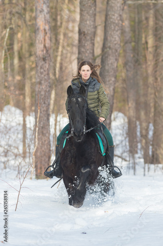 A woman with long hair riding a dark brown horse