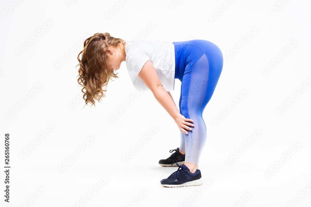 Plus size model in sportswear, fat woman doing workout on white background, body positive concept