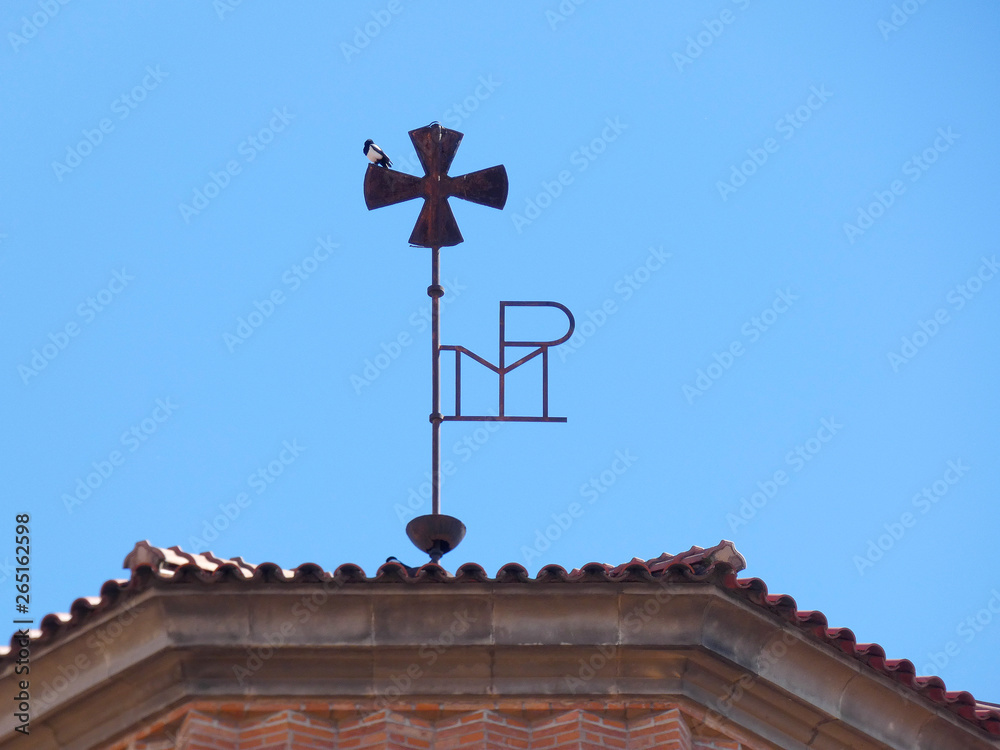 Pájaro posado en la cruz de la catedral de Sant Feliu de Llobregat