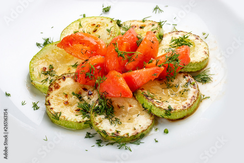 Grilled zucchini with tomatoes on white background