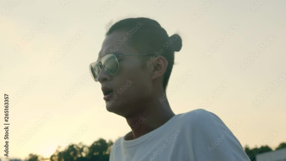young asian adult wearing sunglasses singing enjoying music eyes closed. young asian adult wearing sunglasses singing enjoying music eyes closed.