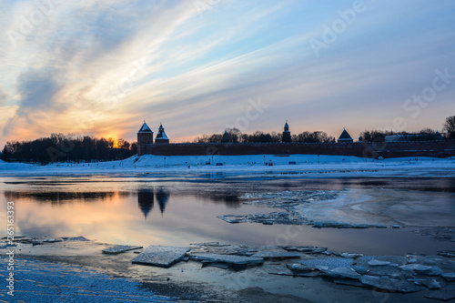 Fototapeta Naklejka Na Ścianę i Meble -  Veliky Novgorod. Kremlin. A beautiful winter sunset over the Kremlin with reflection in the river and ice floes in the foreground.