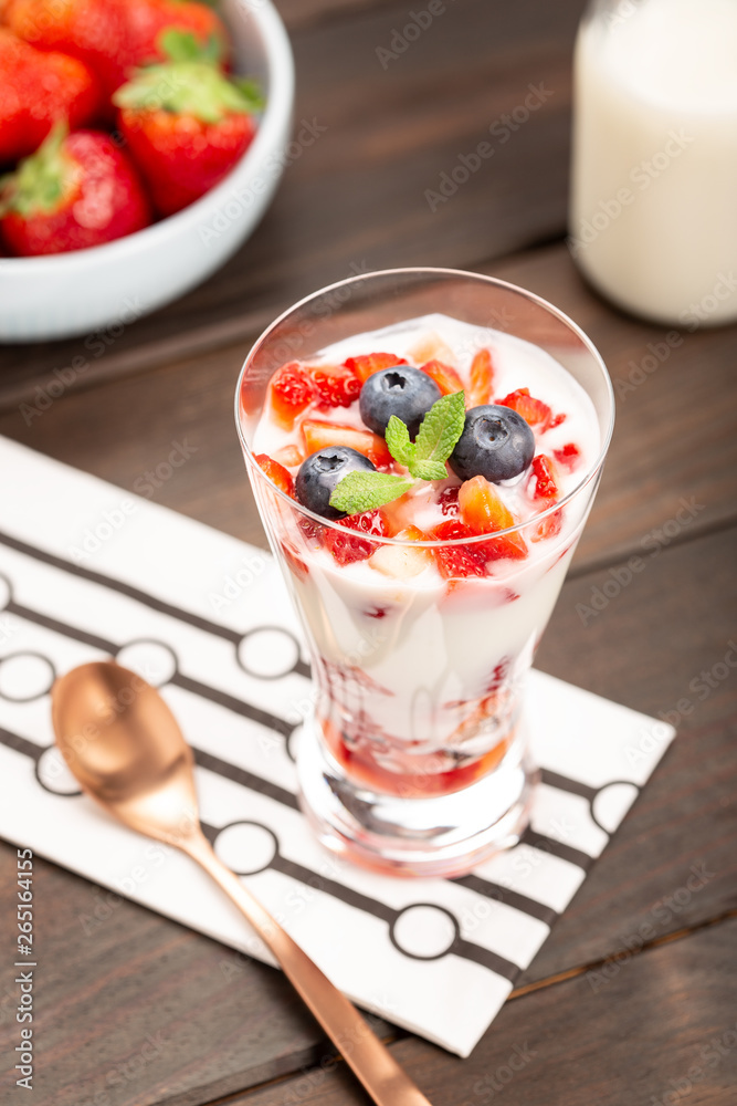 Healthy sweet dessert in glass with strawberries, yogurt and blueberries Healthy sweet dessert in glass with strawberries, yogurt and blueberries