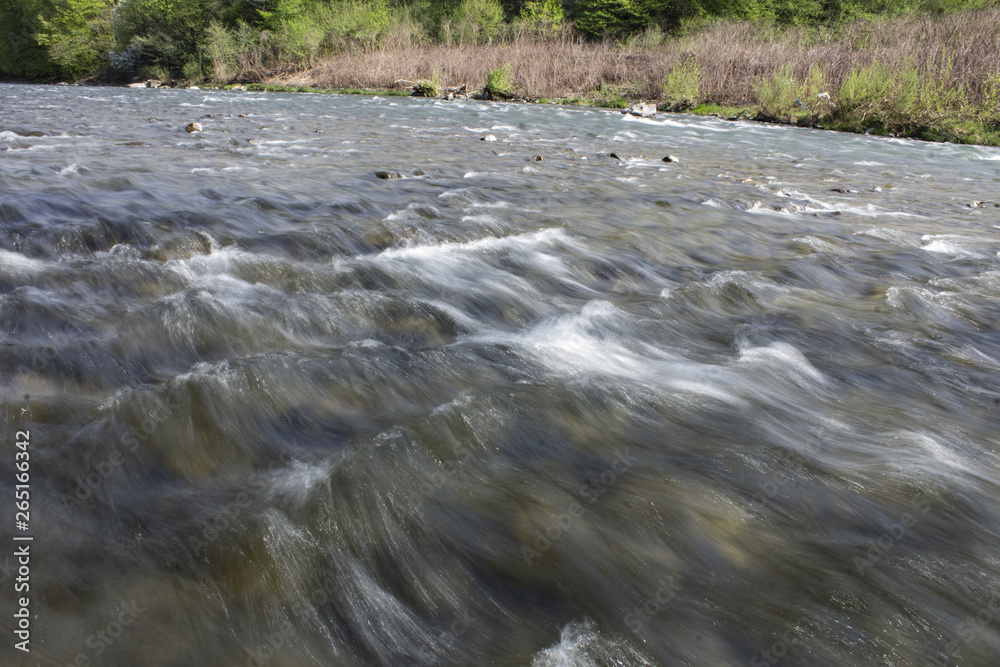 Waters of a mountain stream rolling over underwater stones lying at the bottom, river Latorytsya in the Carpathians, Ukraine. Waters of a mountain stream rolling over underwater stones lying at the bottom, river Latorytsya in the Carpathians, Ukraine.