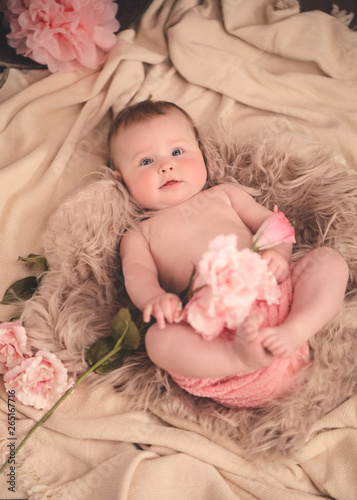 Portrait süßes Baby liegt auf dem Rücken mit rosa Blumen beige