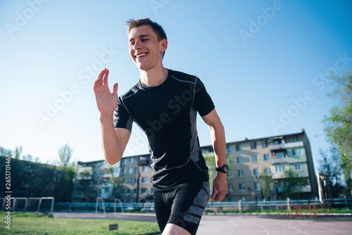 Athlete at the stadium stands on the starting track for running © Alexander