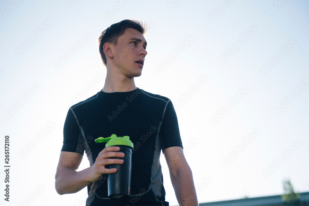 tired athlete man drinking water from a shaker tired athlete man drinking water from a shaker