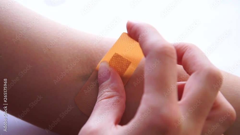 Putting on an adhesive plaster on fresh arm wound Putting on an adhesive plaster on fresh arm wound