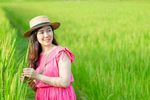 Beautiful and pretty Asian girl in vintage pink dress enjoy relaxing in the beautiful rice field close up. Pretty Asian girl's portrait in rice farm. Vintage girl's portrait.